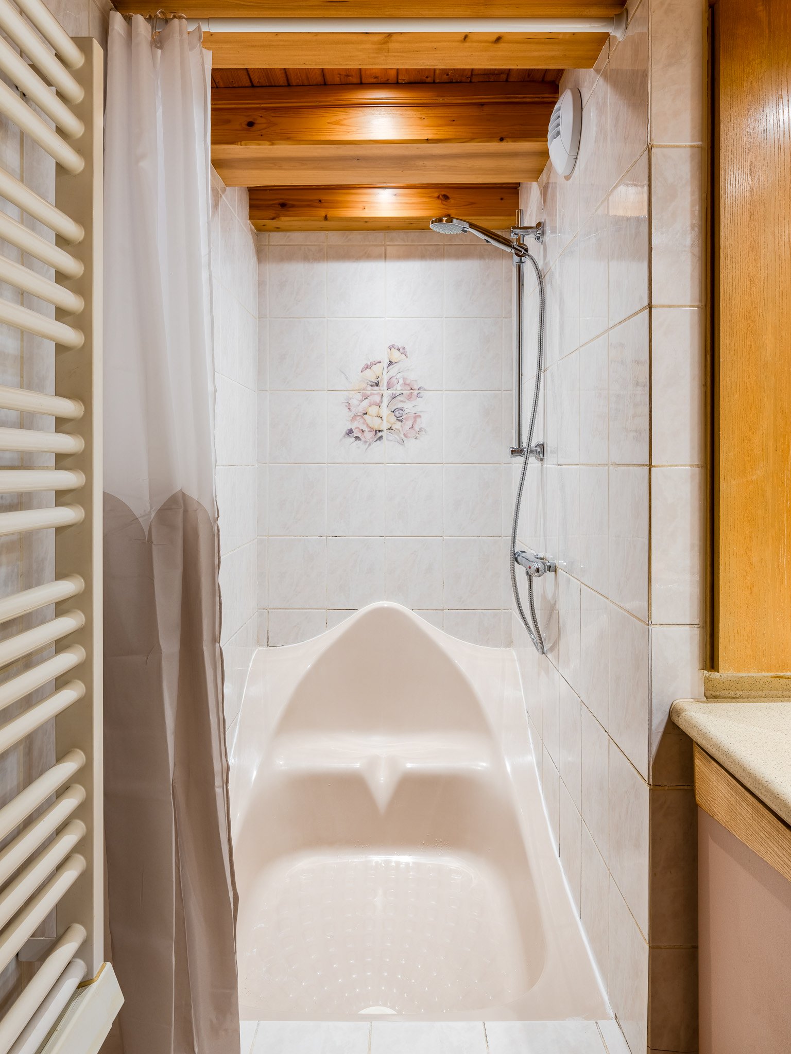 Baignoire avec douche et sèche-serviettes dans la salle de bain