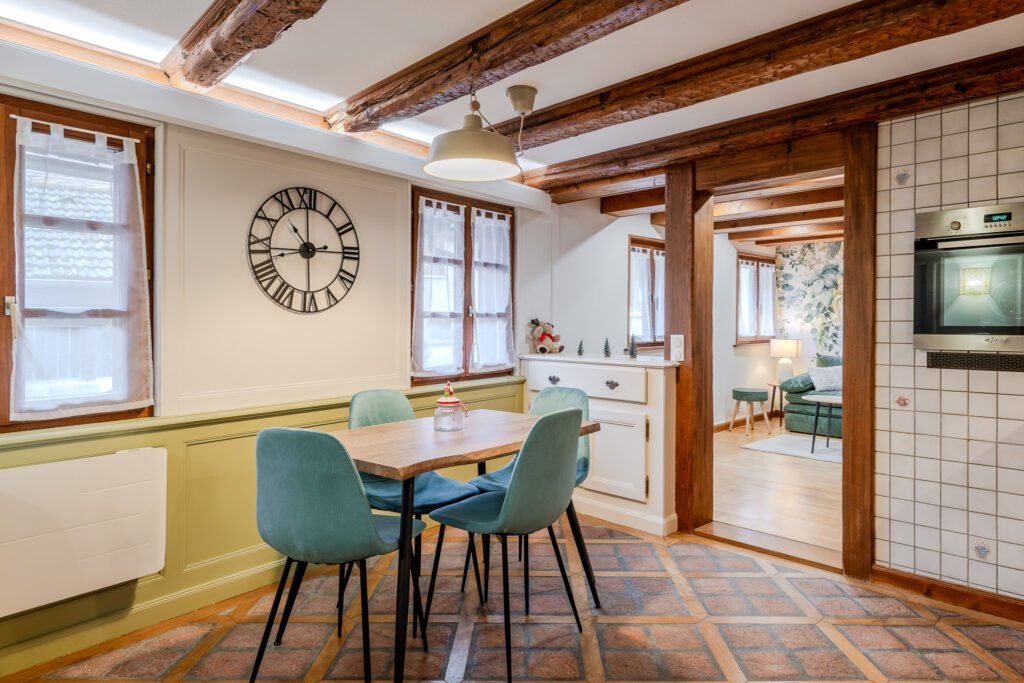 Table de la salle à manger, chaises vertes et poutres apparentes